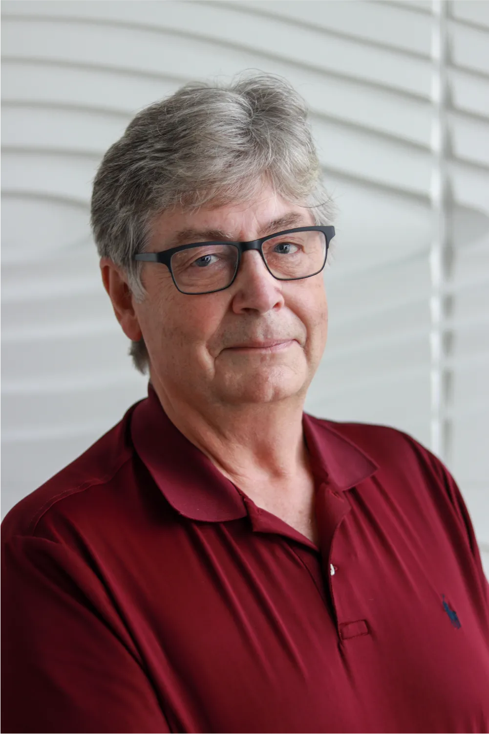 A profile picture of Dr. Stephen Coyle in front of a white wall with a raised wave pattern.