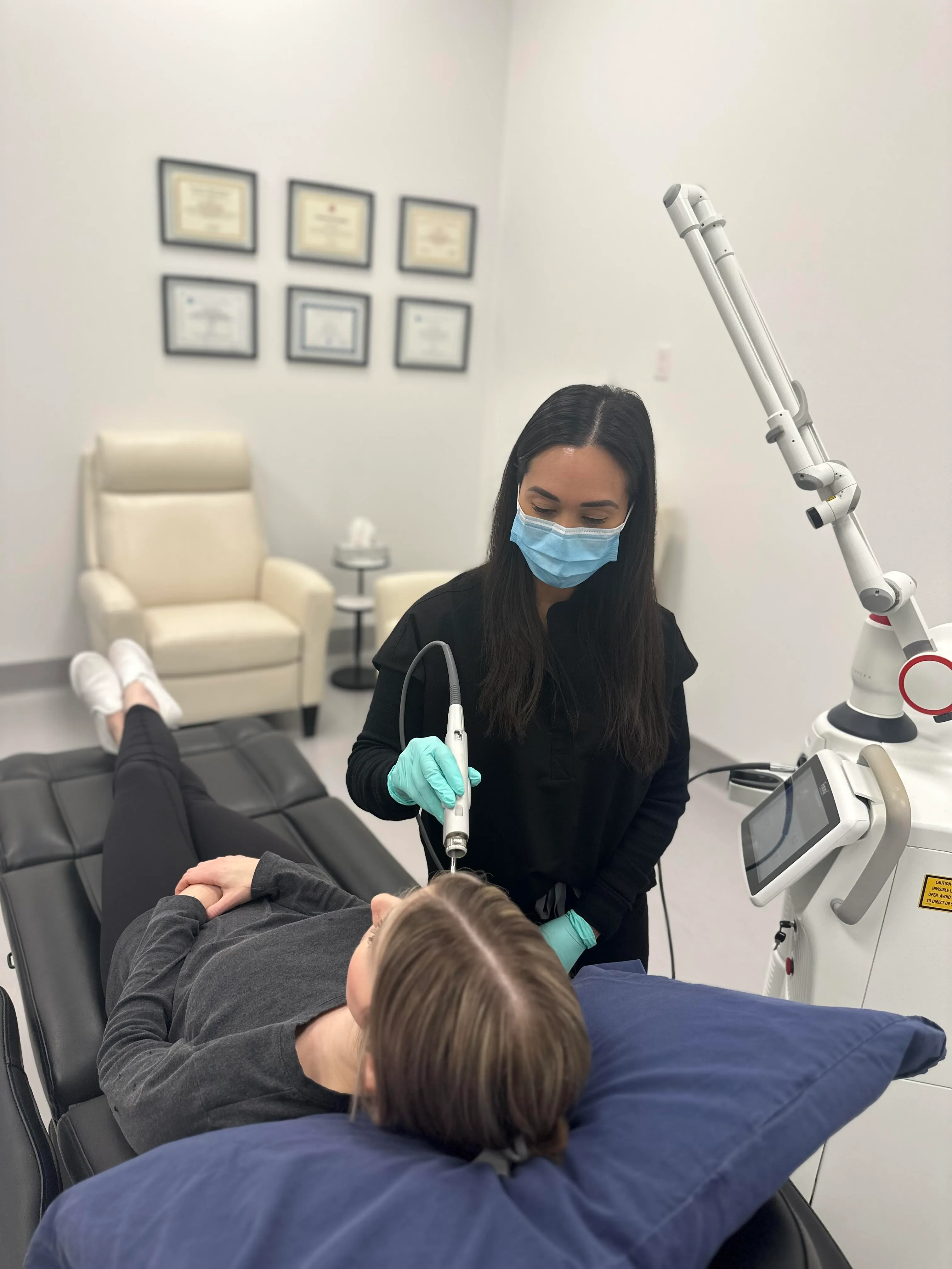 Photo of a woman receiving a laser facial with a Fotona Laser.