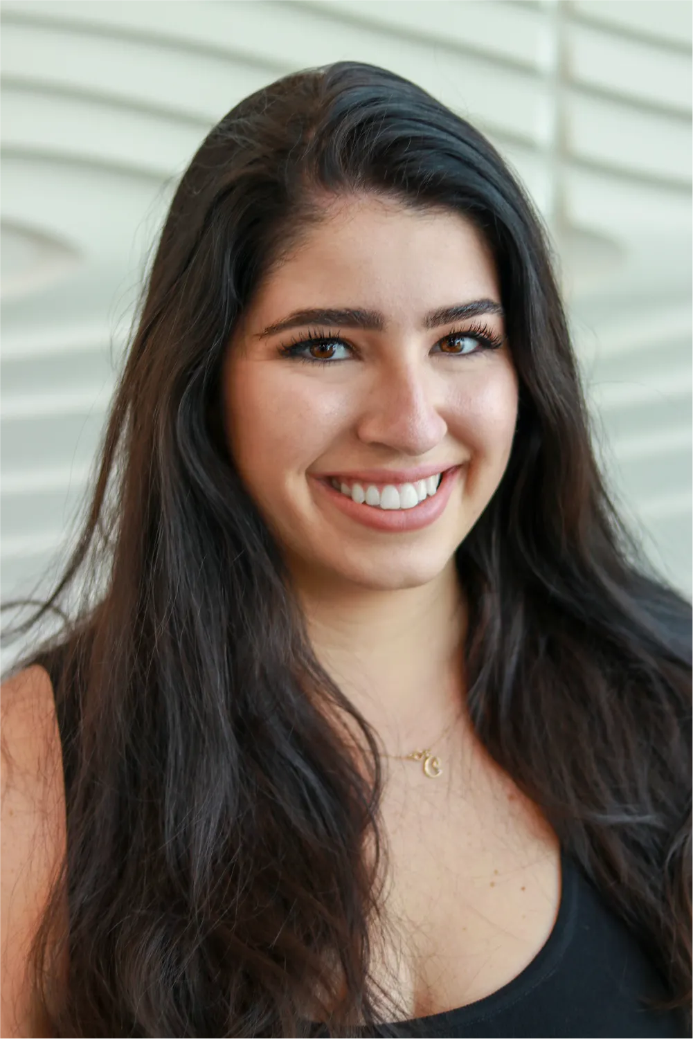 A profile picture of Christina Sawchyn in front of a white wall with a raised wave pattern.
