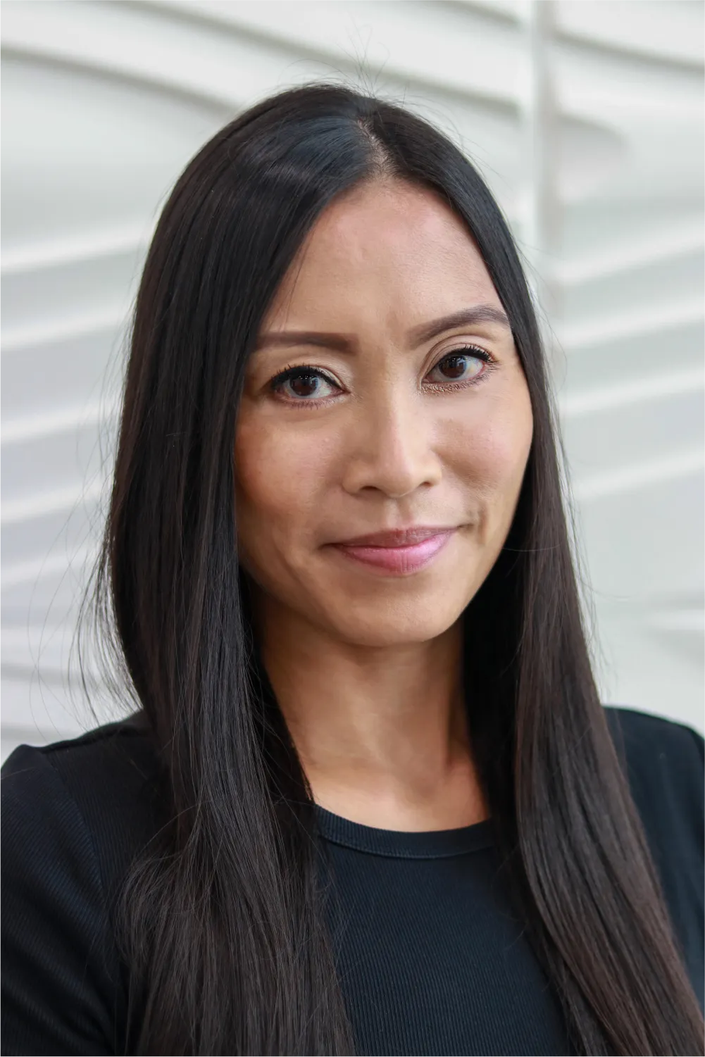 A profile picture of Charlene Bambalan in front of a white wall with a raised wave pattern.