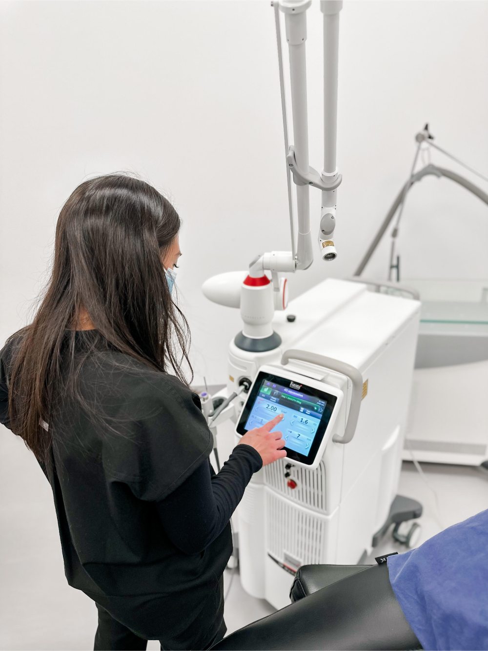 A technician configuring a Fotana Laser machine in preparation for treatment.