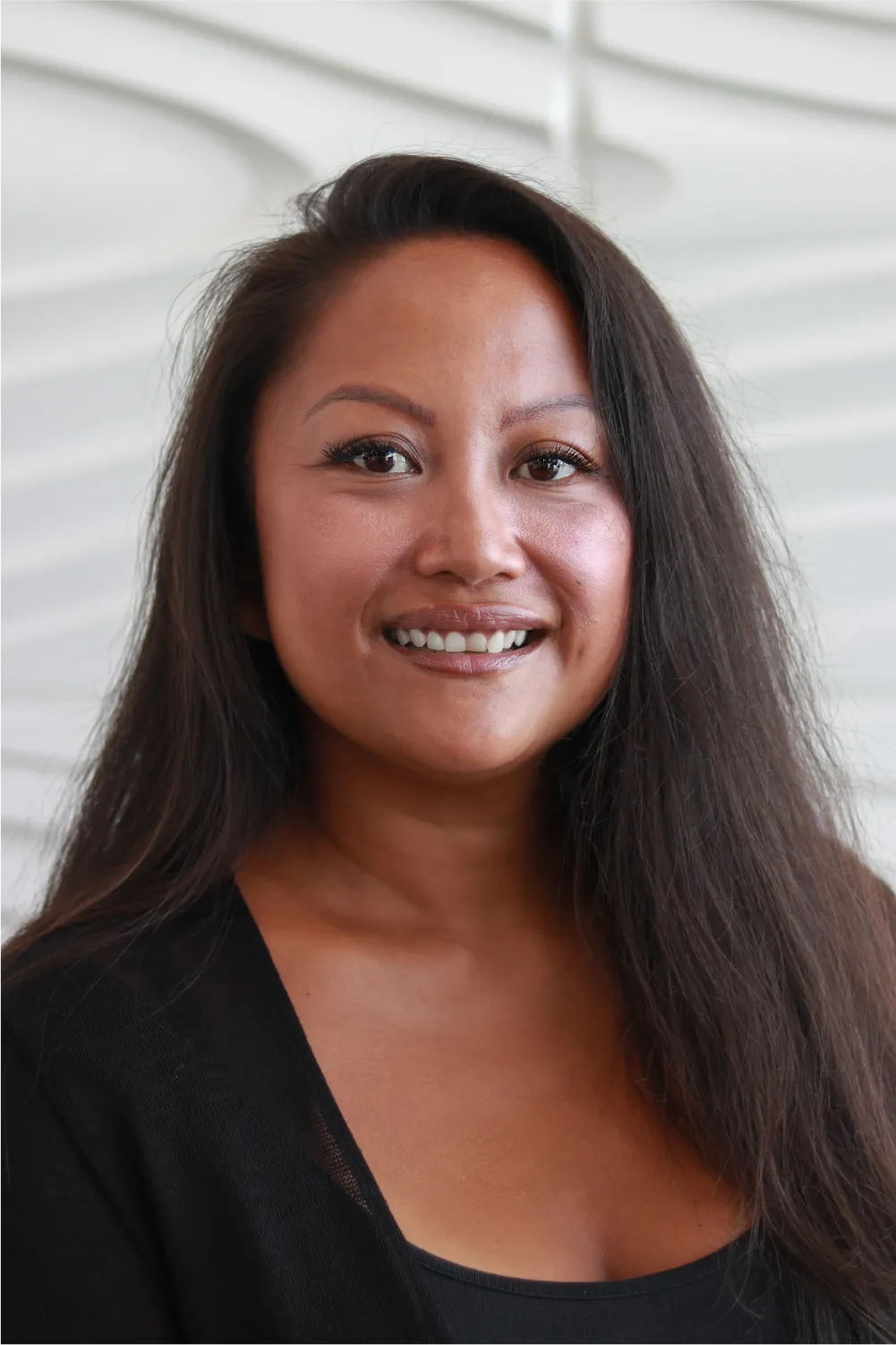 A profile picture of Marjorie Amazic in front of a white wall with a raised wave pattern.