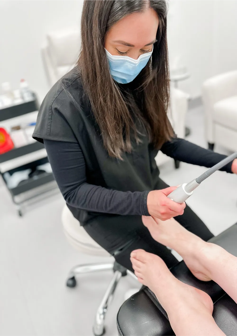 A technician using a Fotana Laser on a patient feet. The nail fungal removal therapy is being applied.
 